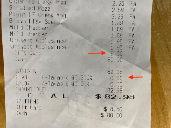 Aldi grocery receipt with the tax and gift card highlighted with an arrow.