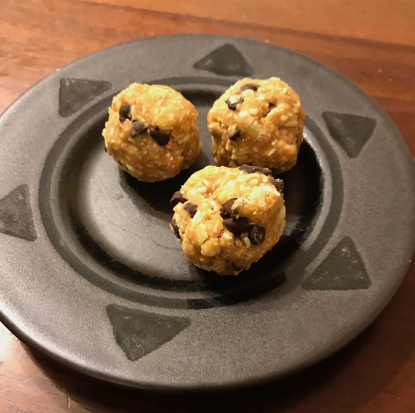 Energy bites on a black plate.