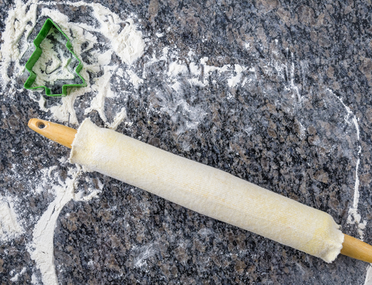 Rolling pin on a floured surface with Christmas Tree cookie cutter