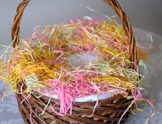 Easter basket with pink, green, yellow, and white grass