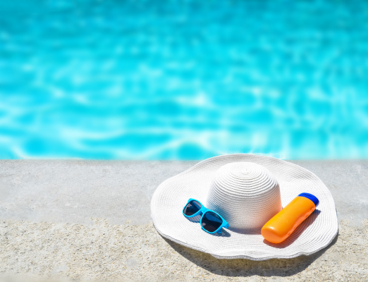 Pool side with hat, glasses, and sunscreen